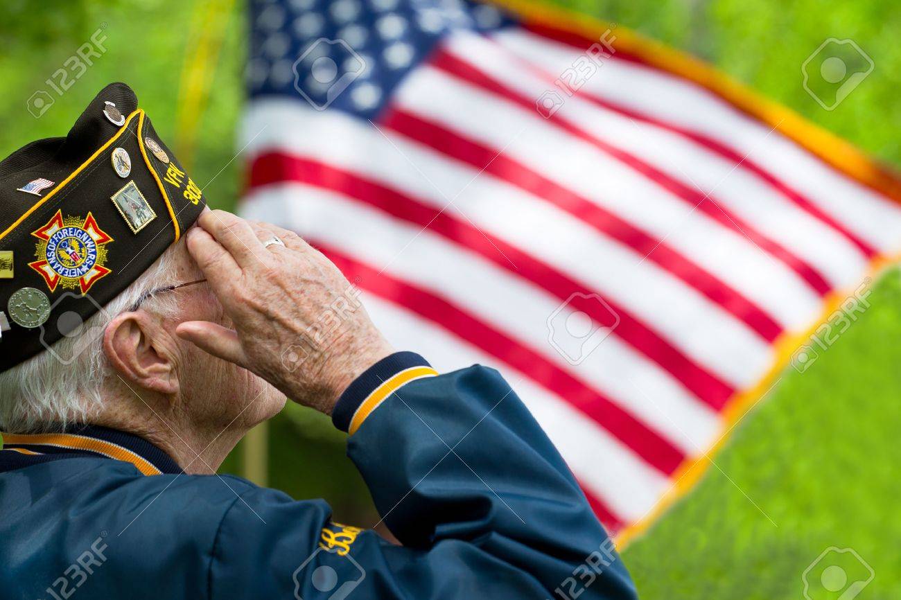 67859392-a-veteran-is-saluting-in-front-of-us-flag-Stock-Photo - Le Bus